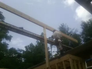 Carpenter setting a ridge beam over a new addition frame — Ice Dam Removal by Roofing Brothers in Casper