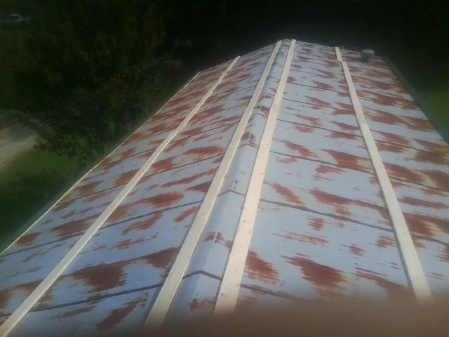 Rusted metal roof panels with new wood purlins before replacement — Storm Damage Roof Repair in Casper by Roofing Brothers