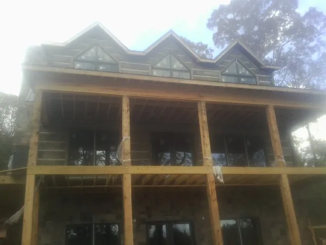 Dormers and porch framing on a large log home under construction — Roof Coating work by our crew in Casper