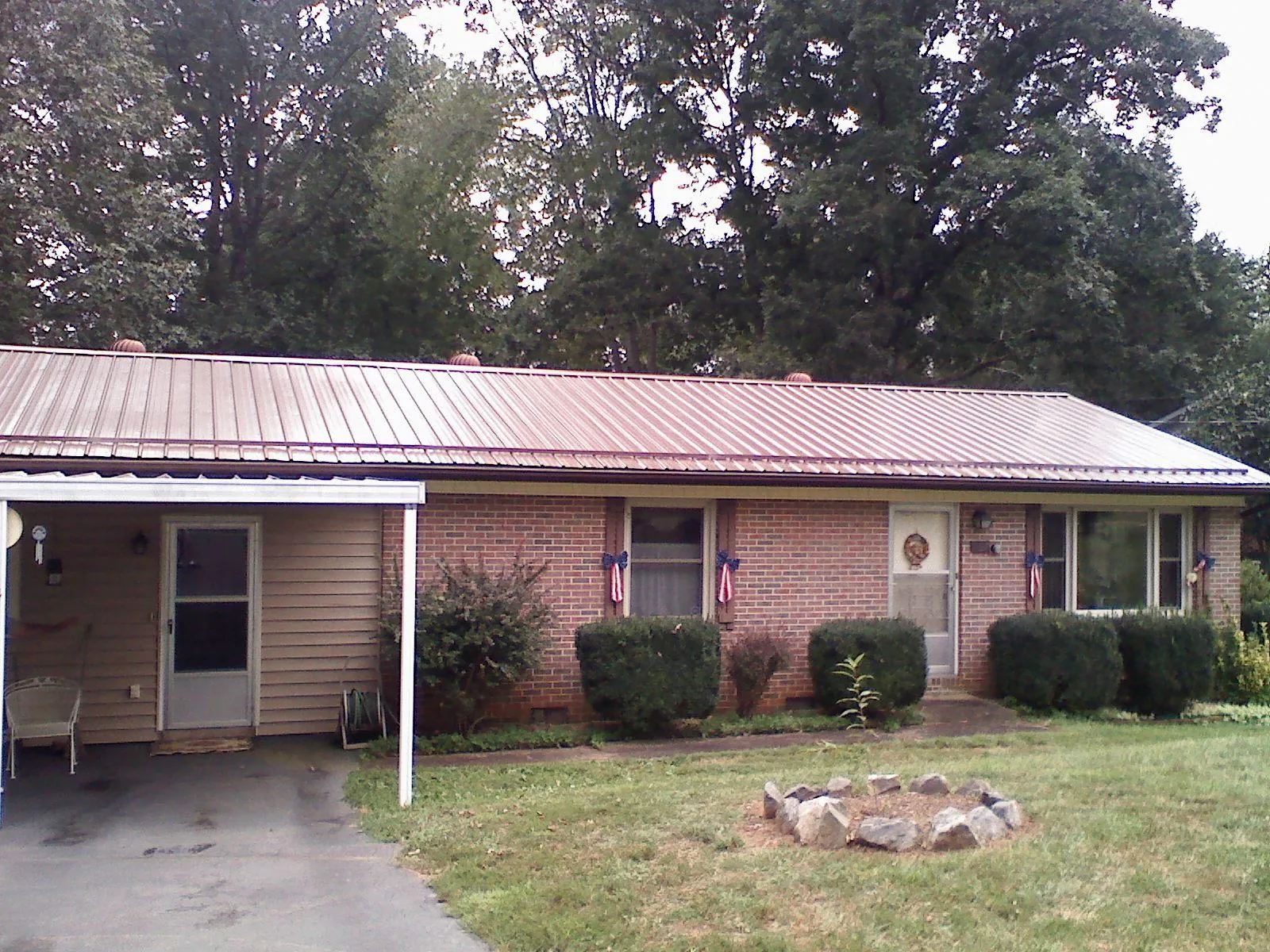 Bronze metal roof and carport on a brick ranch home — Roof Repair work by our crew in Casper